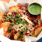 Homemade potato chips get loaded with savory Spanish ingredients in this fusion recipe. Far from ordinary, these nachos are topped with Manchego cheese, Chorizo sausage and served with a fresh, zesty Chimichurri. | vintagekitty.com