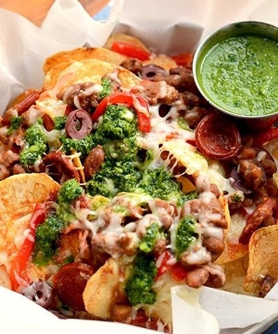 Homemade potato chips get loaded with savory Spanish ingredients in this fusion recipe. Far from ordinary, these nachos are topped with Manchego cheese, Chorizo sausage and served with a fresh, zesty Chimichurri. | vintagekitty.com