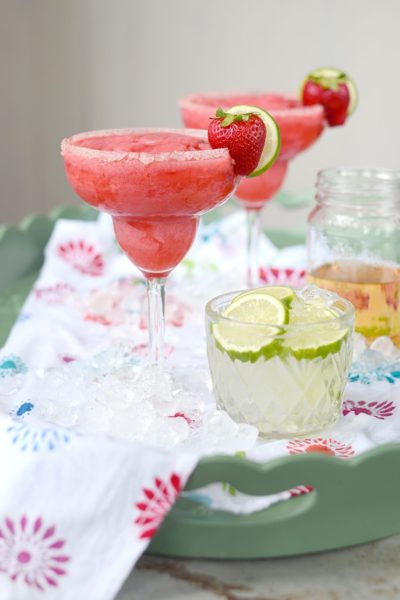 frozen strawberry margaritas garnished with strawberry and lime slice