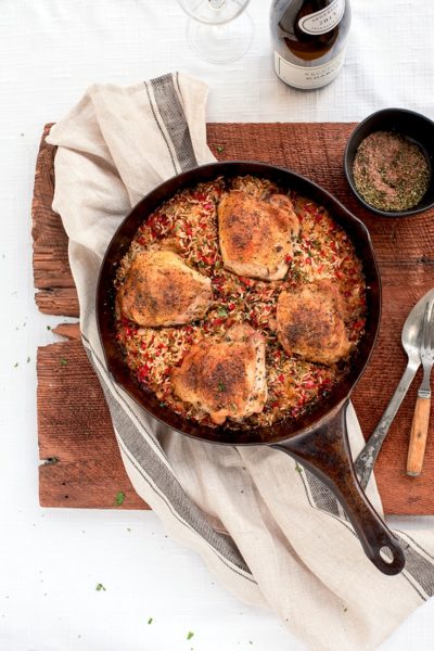 chicken and rice in a cowboy skillet on a rustic wooden board